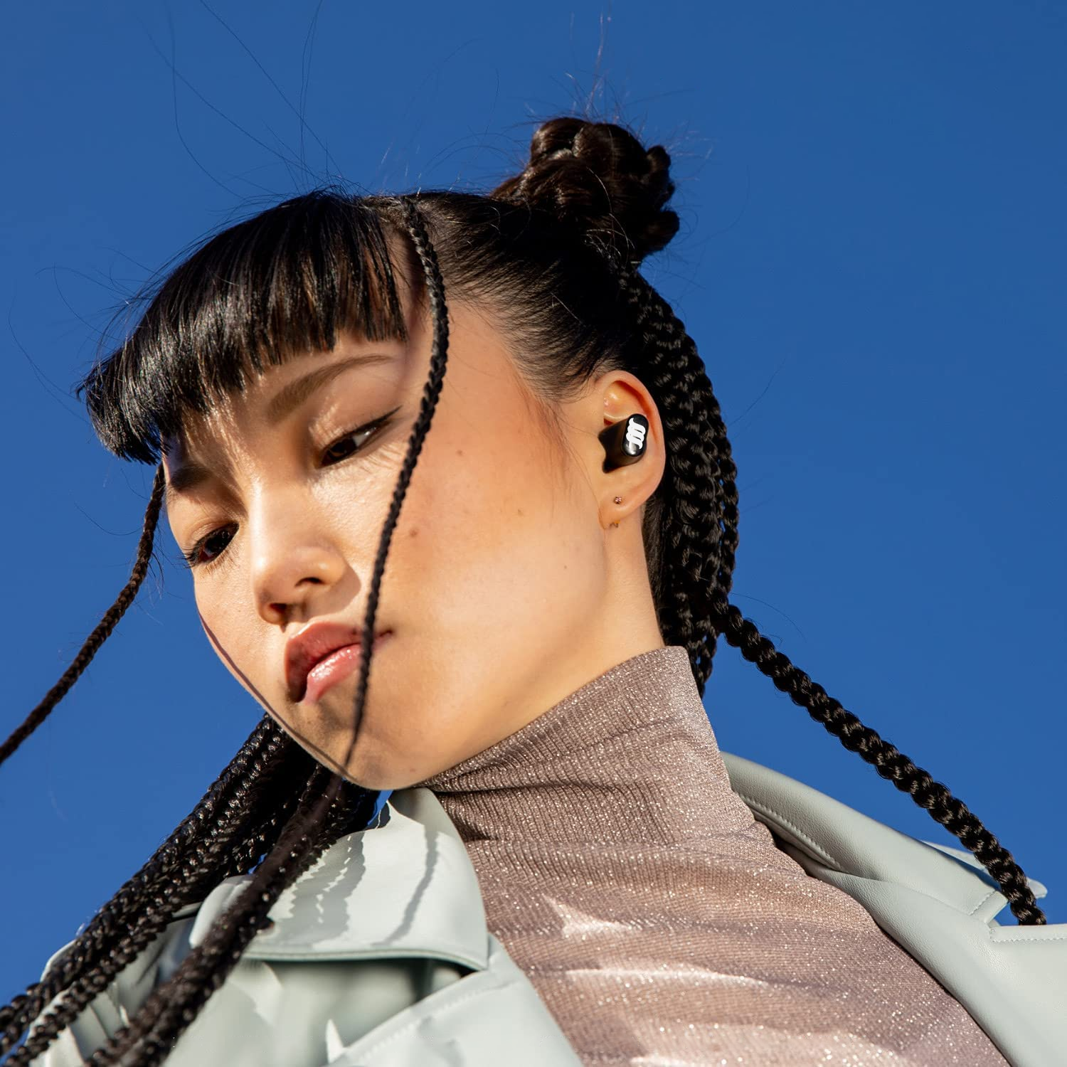 Asian American female model wearing our black WaveBuds. 