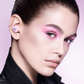 Caucasian female model wearing pink earbuds. 
