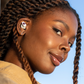 African American female model wearing white earbuds. 
