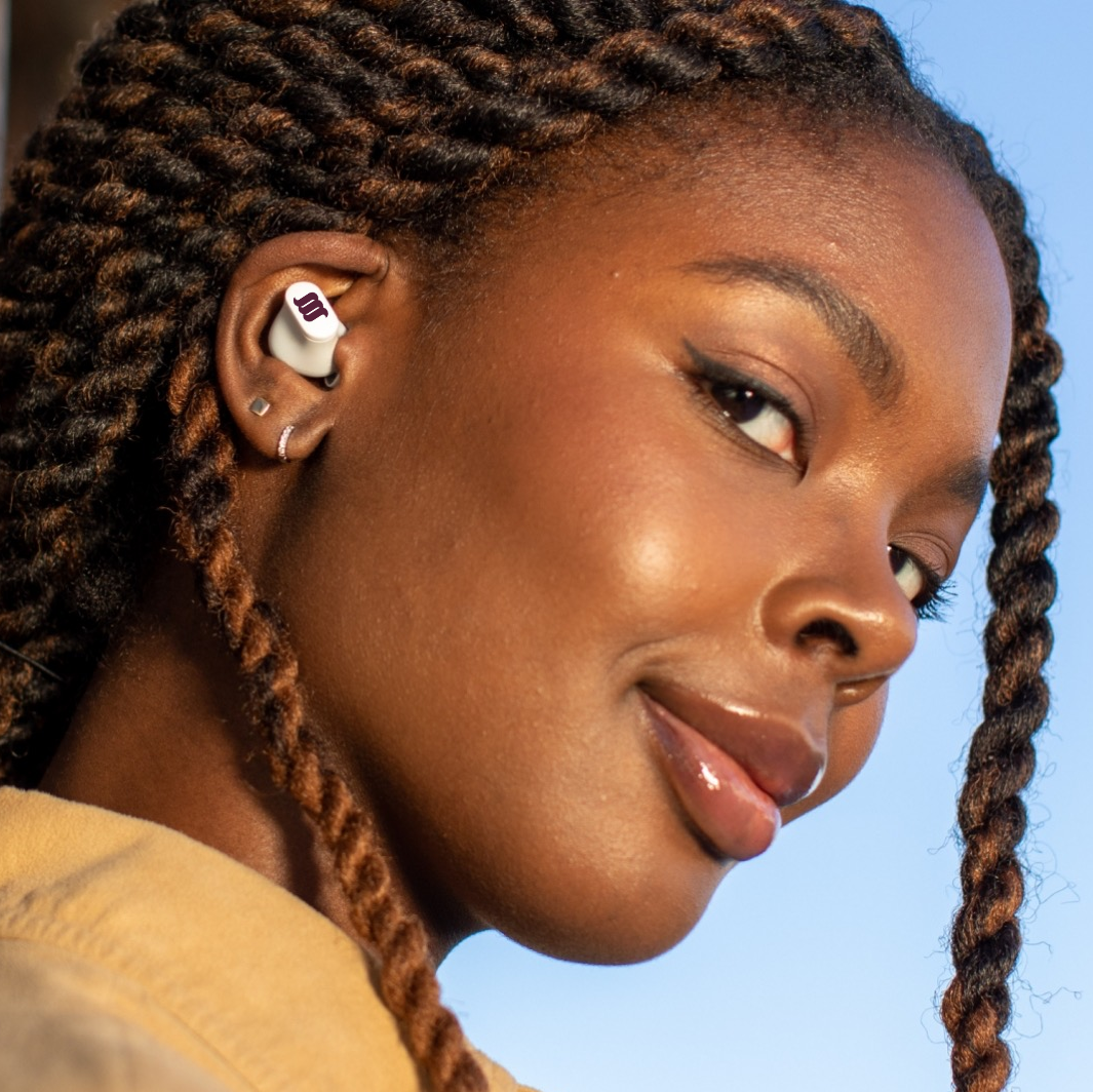 African American female model wearing white earbuds. 