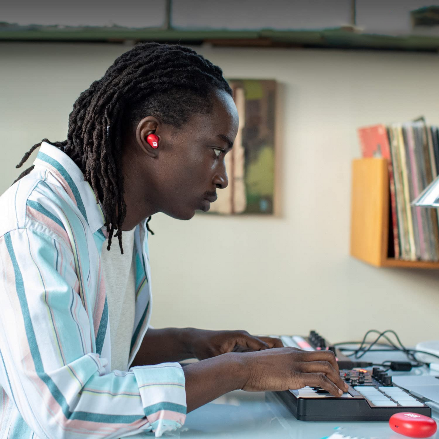 African American student mixing on turntable wearing red WaveBuds.